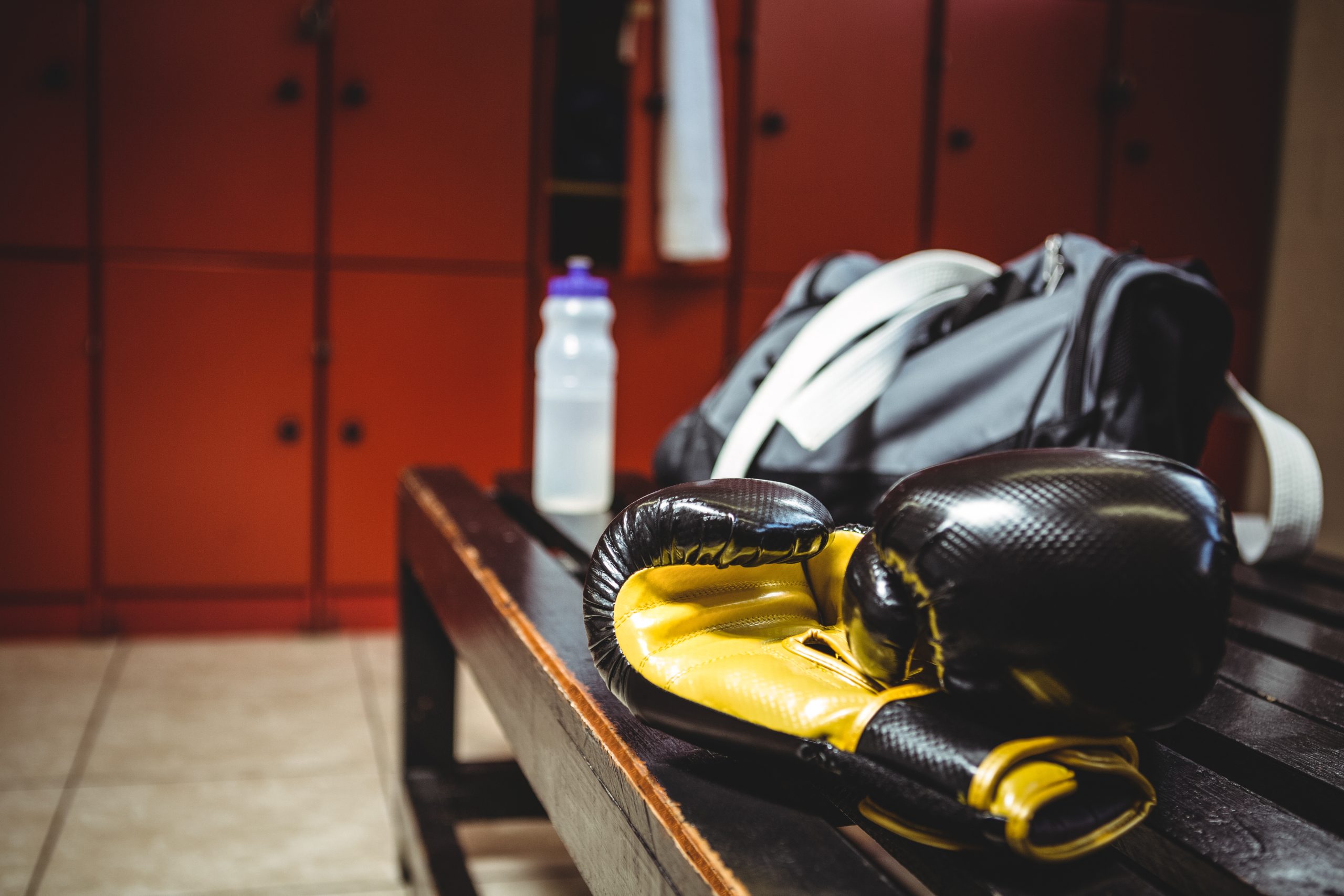 close up of boxing gloves on bench in locker room